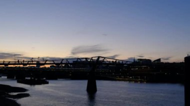 Günbatımında Londra Milenyum Köprüsü 'nde insanlar geziniyor. Yüksek kalite 4k görüntü