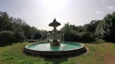 Güneşli bir günde Roma 'daki Eur Parkı' nın ortasındaki çeşme.