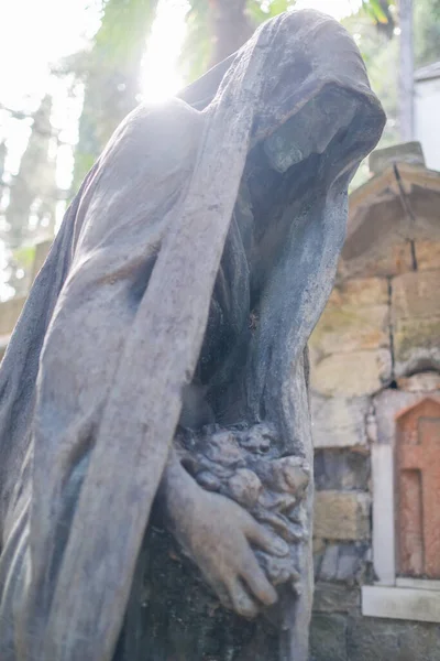 old woman crying statue in abandoned cemetery. High quality photo