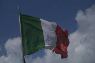Italian tricolor flag waving in the wind in sunny day. High quality photo