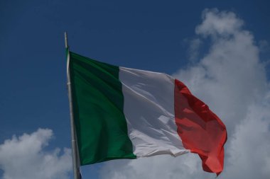 Italian tricolor flag waving in the wind in sunny day. High quality photo