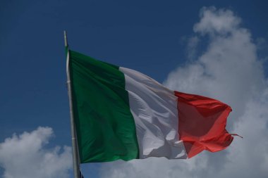 Italian tricolor flag waving in the wind in sunny day. High quality photo