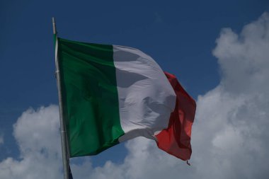 Italian tricolor flag waving in the wind in sunny day. High quality photo