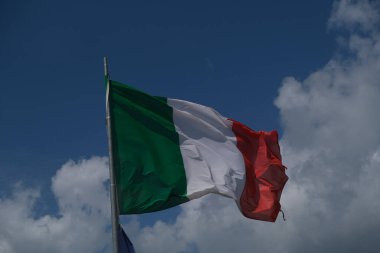 Italian tricolor flag waving in the wind in sunny day. High quality photo
