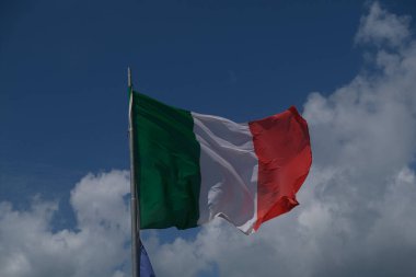 Italian tricolor flag waving in the wind in sunny day. High quality photo