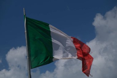 Italian tricolor flag waving in the wind in sunny day. High quality photo