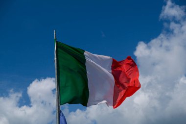 Italian tricolor flag waving in the wind in sunny day. High quality photo