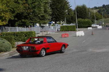 Bibbiano-Reggio Emilia Italy - 07 15 2015 : Free rally of vintage cars in the town square red Fiat X1 9 . High quality photo
