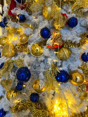 beautiful white christmas tree with gold and blue decorations. High quality photo