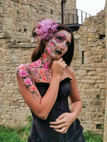 beautiful italian brunette girl with face painted in floral style. High quality photo