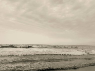 waves on the beach in Italy with dramatic sky. High quality photo