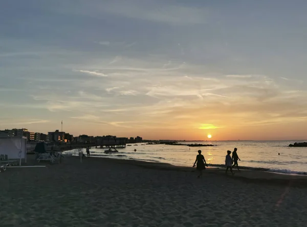 夕阳西下在海滩上 人们在轮廓中 高质量的照片 — 图库照片