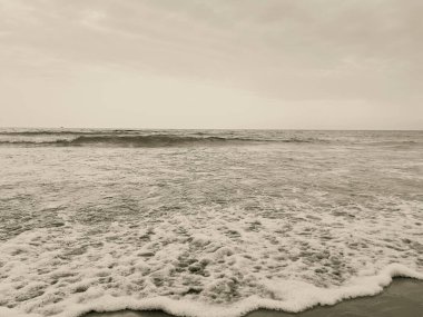 waves on the beach in Italy with dramatic sky. High quality photo