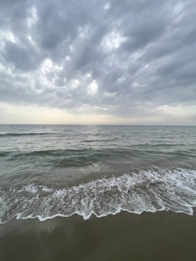 waves on the beach in Italy with dramatic sky. High quality photo