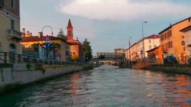 Günbatımında Milano 'daki Naviglio Kanalı' nda yelken açacağız. Yüksek kalite 4k görüntü