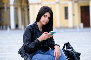 Güzel İtalyan esmer kız akıllı telefon kullanıyor. Yüksek kalite fotoğraf