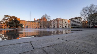 Reggio Emilia Piazza della Vittoria, gün batımındaki çeşmenin yansıması. Yüksek kalite fotoğraf