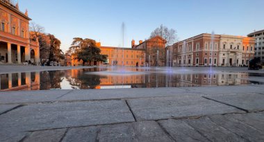 Reggio Emilia Piazza della Vittoria, gün batımındaki çeşmenin yansıması. Yüksek kalite fotoğraf