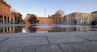 Reggio Emilia Piazza della Vittoria, gün batımındaki çeşmenin yansıması. Yüksek kalite fotoğraf