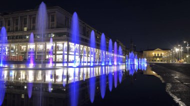 Reggio Emilia Piazza della Vittoria, gece vakti mor ışıklarla çeşmenin yansıması. Yüksek kalite fotoğraf