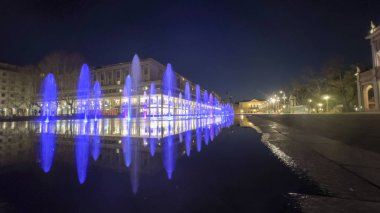 Reggio Emilia Piazza della Vittoria, gece vakti mor ışıklarla çeşmenin yansıması. Yüksek kalite fotoğraf
