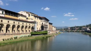 Floransa 'daki Arno nehri güneşli bir günde köprüye bakıyor. Yüksek kalite 4k görüntü