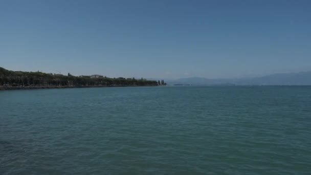 ペシエラの海岸からガルダ湖 遠くのボートで晴れた日のパノラマ 高品質の4K映像 — ストック動画