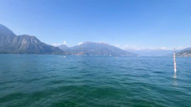 Peschiera sahilinden Garda Gölü, güneşli bir günde, uzaktaki teknelerle panorama. Yüksek kalite 4k görüntü