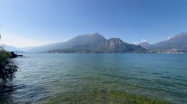 Peschiera sahilinden Garda Gölü, güneşli bir günde, uzaktaki teknelerle panorama. Yüksek kalite 4k görüntü