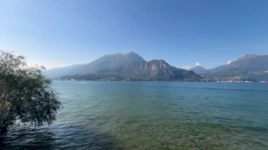 Peschiera sahilinden Garda Gölü, güneşli bir günde, uzaktaki teknelerle panorama. Yüksek kalite 4k görüntü