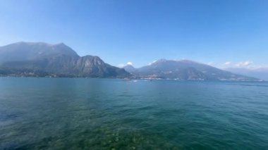 Peschiera sahilinden Garda Gölü, güneşli bir günde, uzaktaki teknelerle panorama. Yüksek kalite 4k görüntü