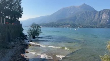 Peschiera sahilinden Garda Gölü, güneşli bir günde, uzaktaki teknelerle panorama. Yüksek kalite 4k görüntü