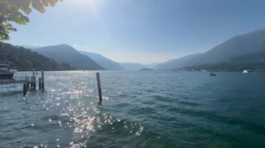 Peschiera sahilinden Garda Gölü, güneşli bir günde, uzaktaki teknelerle panorama. Yüksek kalite 4k görüntü