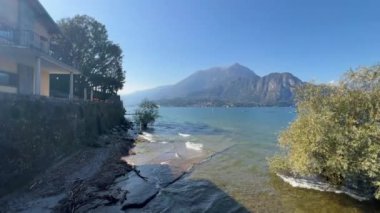 Peschiera sahilinden Garda Gölü, güneşli bir günde, uzaktaki teknelerle panorama. Yüksek kalite 4k görüntü