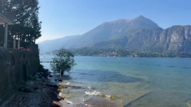 Peschiera sahilinden Garda Gölü, güneşli bir günde, uzaktaki teknelerle panorama. Yüksek kalite 4k görüntü