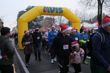 Bibbiano, Reggio Emilia - İtalya: 2022 18 12 BabboRun serbest koşu yarışı Noel Baba gibi giyinmiş koşucularla. Yüksek kalite fotoğraf