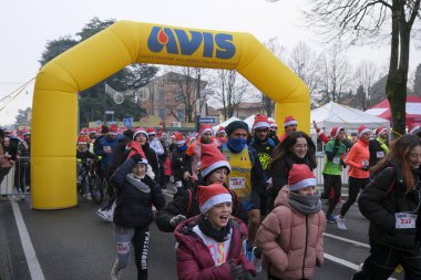 Bibbiano, Reggio Emilia - İtalya: 2022 18 12 BabboRun serbest koşu yarışı Noel Baba gibi giyinmiş koşucularla. Yüksek kalite fotoğraf