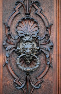 Aslan kafalı bu kahverengi kapı tokmağı evinizin kapısının yaratıcı sanat armaşıdır. Ahşap leke, aslan sembolünün karmaşık desenini ve simetrisini arttırır.