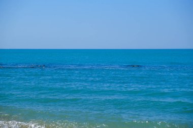 Su, gökyüzü, bulutlar, sıvı, plaj, rüzgar dalgası, ufuk, elektrik mavisi ve rüzgar gibi anahtar sözcükleri barındıran berrak mavi gökyüzü altında engin bir su genişliği.