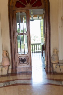 Kapı balkonlu bir odaya açılıyor, iç dizayn, ahşap döşeme ve ahşap döşeme karışımını gösteriyor, uzaya bir parça sanat katıyor.