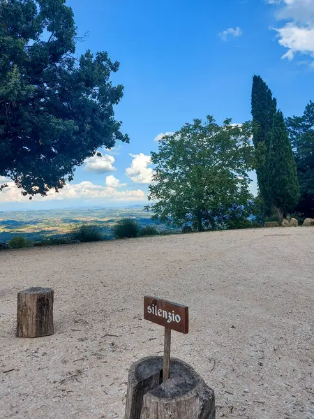 stock image A gravel area with a sign displaying the letter a, surrounded by clouds, sky, buildings, plants, trees, grass, creating a serene natural landscape perfect for city recreation