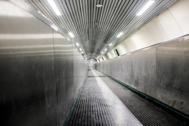 Geniş açılı bir açıyla çekilen, metro istasyonunda parlak bir tasarımı olan modern bir yürüyen merdiven.