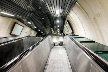Geniş açılı bir açıyla çekilen, metro istasyonunda parlak bir tasarımı olan modern bir yürüyen merdiven.