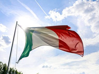 Güzel İrlanda bayrağı zarif bir şekilde dalgalanıyor ve gri, bulutlu bir gökyüzü altında dalgalanarak İrlanda 'nın gururunu simgeliyor.