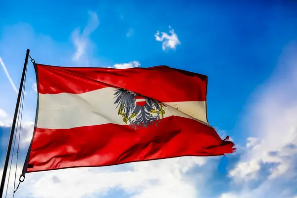 stock image The national flag of Austria waves gracefully and proudly against a stunning natural backdrop of landscape beauty