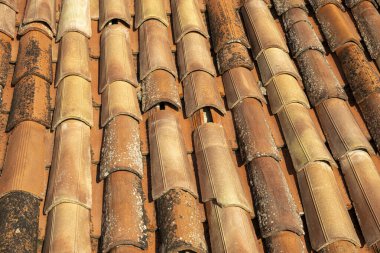 Bu, yüzeyini kaplayan sayısız kiremitten oluşan geniş bir yerleşime sahip bir çatının yakın görüntüsü.