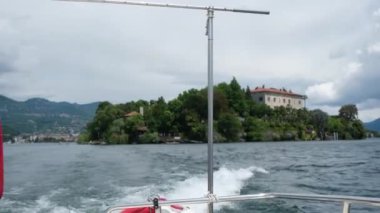 Maggiore Gölü 'nde balıkçı adasının arka planında tekneyle. Yüksek kalite 4k görüntü