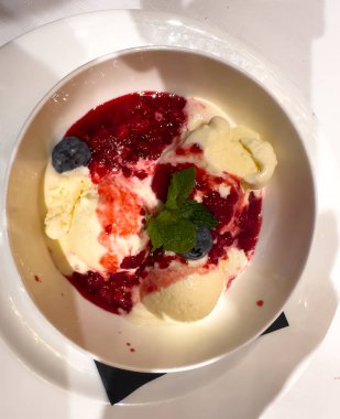 Lezzetli bir kase lezzetli dondurma üzerine taze böğürtlen ve taze nane yapraklarıyla süslenmiş tat katmak için.