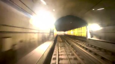 Dinamik bir video, parlayan ışıklarla aydınlanan, yolculuk ve macera hissi uyandıran karanlık bir tünelden geçen bir metro tünelini gösteriyor.