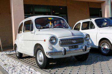 Bibbiano-Reggio Emilia Italy - 07 15 2015 : Free rally of vintage cars in the town square Fiat 600 white. High quality photo clipart